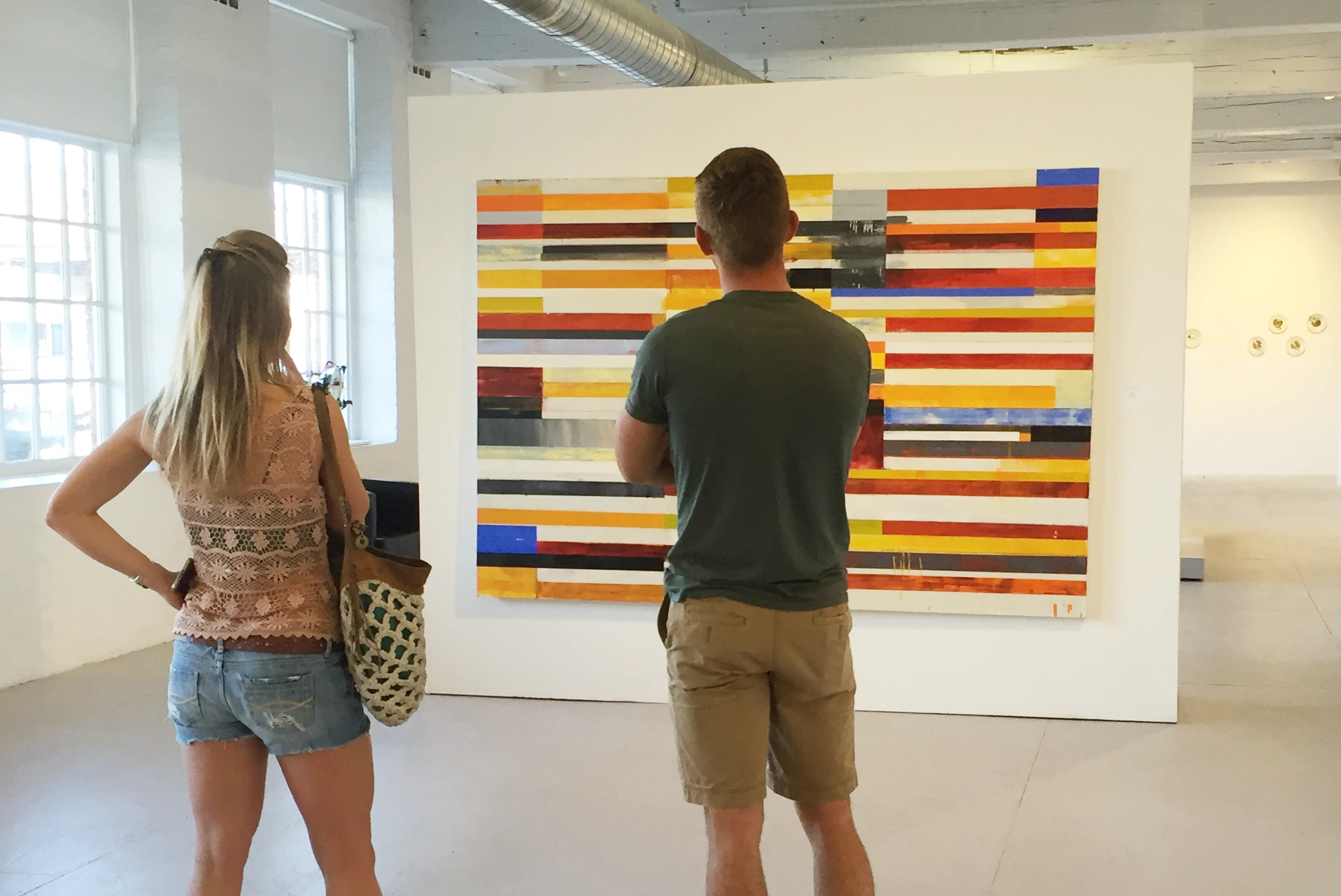 two exhibit-goers viewing work by Lloyd Martin at Mass MOCA gallery